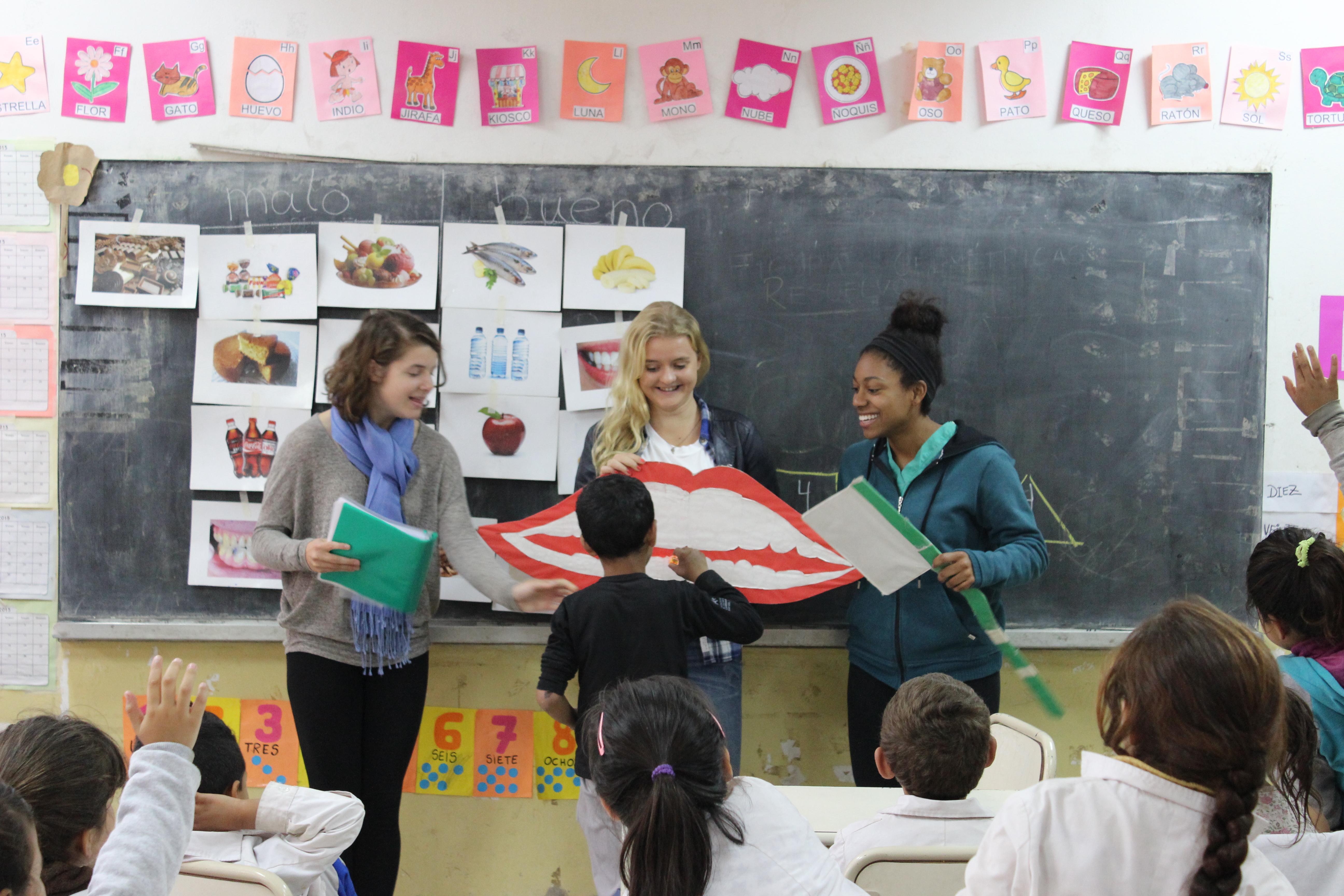 Two teaching volunteers run a dental hygiene class during their teaching work experience in Argentina Projects Abroad volunteers teaching their students about dental hygiene in Argentina